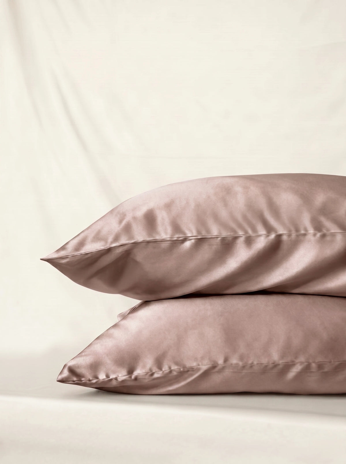 Taie d'oreiller en soie 22 mommes beige empilé sur fond ivoire.