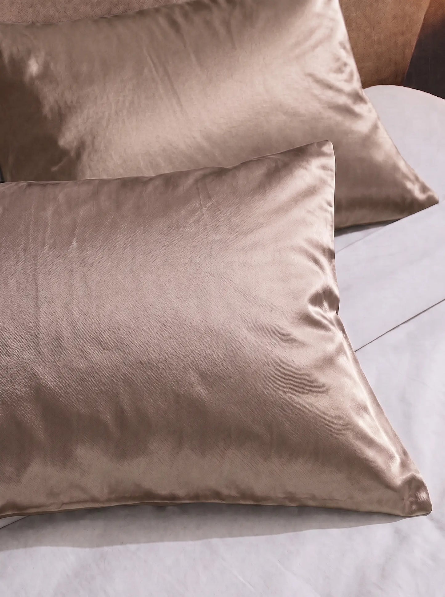 2 taie d'oreiller en soie 25 mommes beige sur lit blanc.