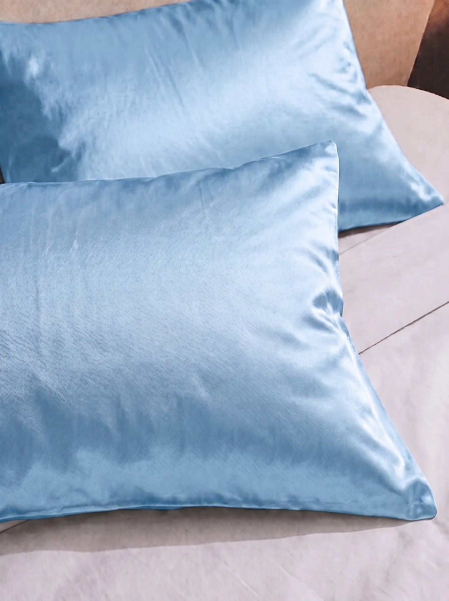 2 taie d'oreiller en soie 25 mommes bleu ciel sur lit blanc.