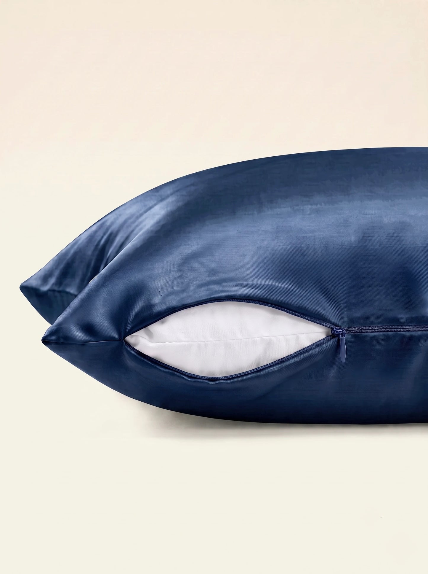 Taie d'oreiller en soie 25 mommes bleu marine, zoom sur les détails de la fermeture éclair, sur fond ivoire.
