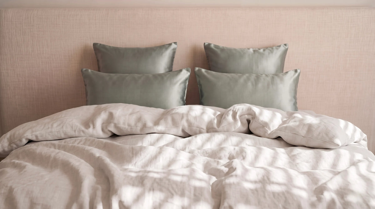4 taies verte pâle centré sur un lit blanc ivoire.
